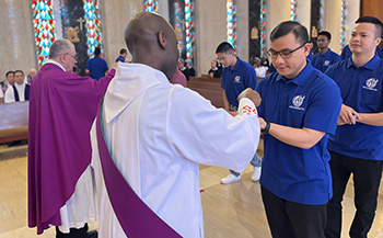 Vietnamese seminarian receiving Holy Communion in Catholic Church