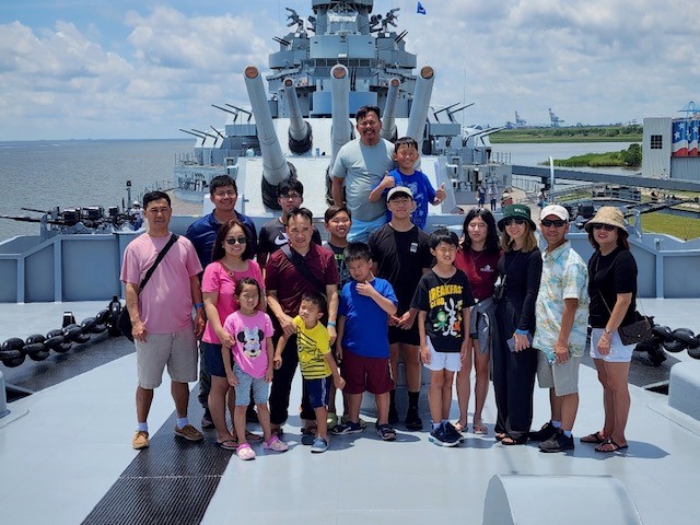 Group posing for a photo on a gun ship